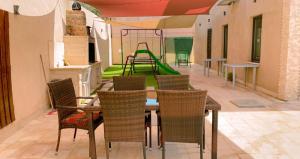 a dining room with a table and chairs and a playground at Celina's farm in Al Rama