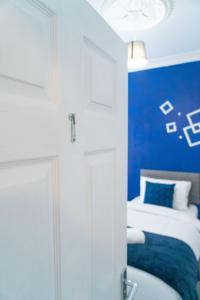 a bedroom with a bed with a blue wall at MMR Homes in Carlisle