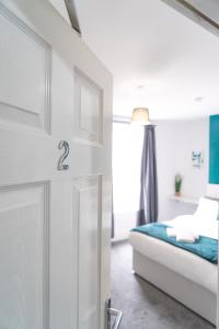 a white bedroom with a bed and a door at MMR Homes in Carlisle