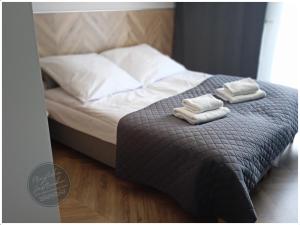 a bed with two folded towels on top of it at Przytulna Jastrzębia in Jastrzębia Góra