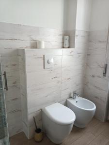 a white bathroom with a toilet and a sink at Decò & Retrò apartment in La Spezia