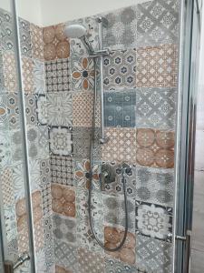 una doccia in bagno con piastrelle sul muro di Decò & Retrò apartment a La Spezia