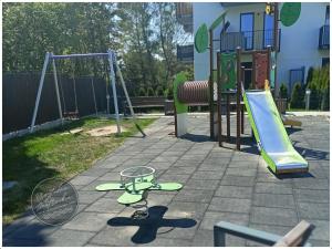 a playground with a slide and a swing set at Przytulna Jastrzębia in Jastrzębia Góra
