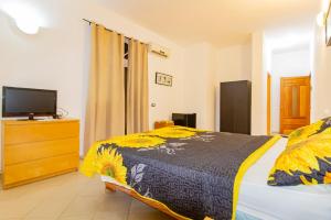 Hotel Villa Capri في بوكا شيكا: غرفة نوم مع سرير وتلفزيون في خزانة