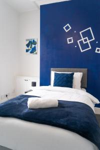 a blue and white bedroom with a large bed at MMR Homes in Carlisle