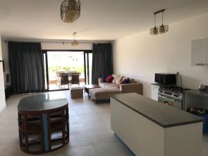 a kitchen and living room with a couch and a table at Swanlake north coast in Zāwiyat al ‘Awwāmah +7 photos
