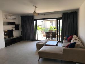 a living room with a couch and a table at Swanlake north coast in Zāwiyat al ‘Awwāmah