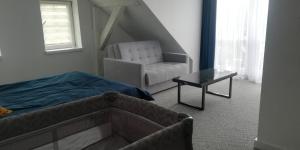 ミコワイキにあるMazuria Inulecのベッドルーム1室(ベッド1台、椅子、テーブル付)