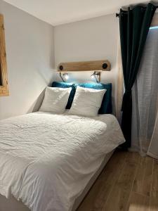 a bed with white sheets and pillows in a bedroom at Somptueux studio de 17m2 Bernex in Bernex