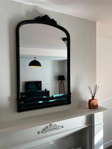 espejo sobre una chimenea en la sala de estar en Appartement Le Sithiu, en Saint-Omer