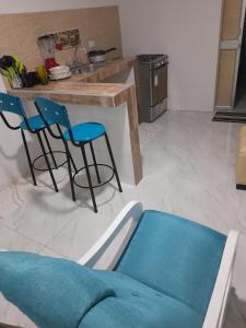 cocina con mesa y 2 sillas azules en APARTA ESTUDIO PERLA ROJA, en Ríohacha