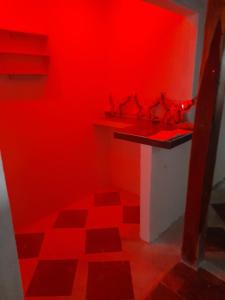 Habitación roja con lavabo y pared roja. en APARTA ESTUDIO PERLA ROJA, en Ríohacha