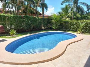 a swimming pool in a yard with trees and bushes at Casa Famari at Playa Bejuco in Bejuco