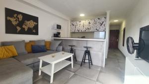 sala de estar con sofá y cocina en The SunSpot Apartment Playa del Inglés en Maspalomas