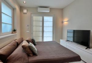 - une chambre avec un canapé et une télévision à écran plat dans l'établissement Villa Carli in centro a Forte dei Marmi, à Forte dei Marmi