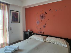 ein Schlafzimmer mit einem Bett und einer orangefarbenen Wand in der Unterkunft Casa Parco Aranci in Formia