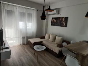 uma sala de estar com um sofá e uma mesa em Apartman ELENA em Jagodina
