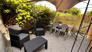 un patio con mesa, sillas y sombrilla en Mille et une nuit, appartement classé 3 étoiles en RDC avec exterieur et parking, en Dole