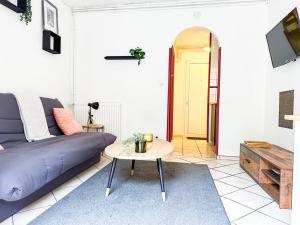 a living room with a purple couch and a table at NEW ! Le Coeur de ville avec terrasse! Parking in Guingamp