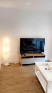 a living room with a large flat screen tv at Tee SweetLux Apartment in London