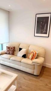 a living room with a white couch with pillows on it at Tee SweetLux Apartment in London