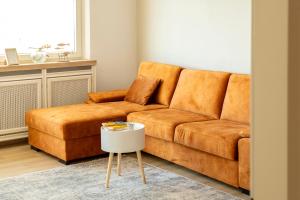 ein braunes Sofa im Wohnzimmer mit einem Tisch in der Unterkunft Seeblick Bregenz in Bregenz