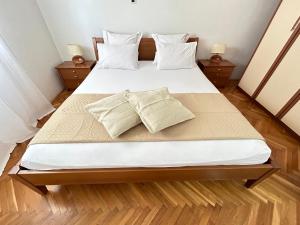 1 dormitorio con 1 cama grande con sábanas y almohadas blancas en Beach Apartment Lux View, en Split