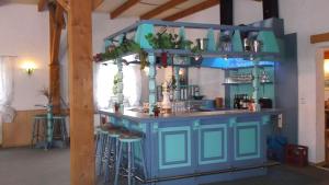 a blue bar with stools in a room at Gasthof Lindenkrug in Broderstorf
