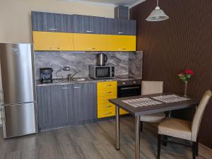 a kitchen with yellow and gray cabinets and a table at Venice Apartments in Sofia