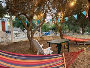 een paar hangmatten en een tafel en bomen bij Relax Torre lapillo in Torre Lapillo