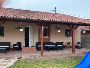 a pavilion with chairs and tables in front of a house at Apartmány Dimitra in Štúrovo