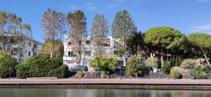 a building next to a body of water with trees at Casa Mazzarini in Cesenatico