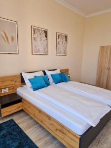 1 dormitorio con 1 cama grande con almohadas azules en ORI Classy Apart Malul Mureșului en Arad