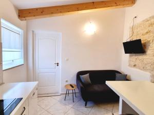 ein Wohnzimmer mit einer schwarzen Couch und einem Tisch in der Unterkunft Stone House Mate in Rovinjsko Selo