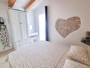 ein Schlafzimmer mit einem Bett und einem Herz an der Wand in der Unterkunft Stone House Mate in Rovinjsko Selo