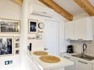 a kitchen with white cabinets and a clock on the wall at Stone House Mate in Rovinjsko Selo