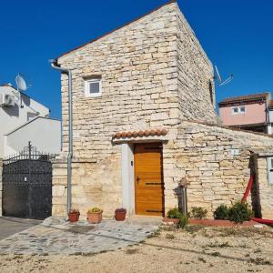 ein Steingebäude mit einer Holztür und einer Tür in der Unterkunft Stone House Mate in Rovinjsko Selo