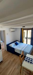 ein Schlafzimmer mit einem blauen Bett in einem Zimmer in der Unterkunft 3 Apartamento tipo estudio ideal para tus vacaciones in Tarragona
