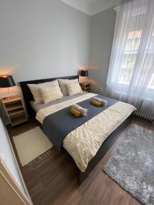 um quarto com uma cama grande com duas almofadas em Larix apartman em Budapeste