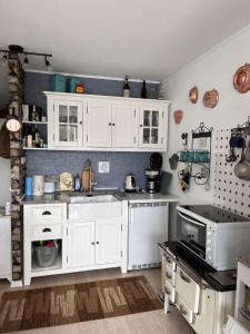 eine Küche mit weißen Schränken und einem Waschbecken in der Unterkunft Appartement Hüttenzauber in Sankt Englmar in Sankt Englmar