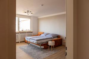 sypialnia z łóżkiem, kanapą i oknem w obiekcie Seeblick Bregenz w Bregencji