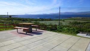 a bench on a patio with a view of the ocean at Cappa House B&B in Eyeries