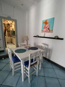 ein weißes Esszimmer mit einem weißen Tisch und Stühlen in der Unterkunft Blue Flat in Neapel