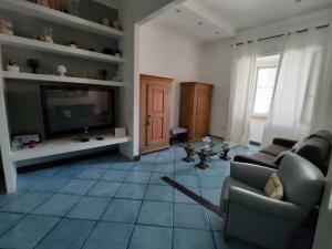 ein Wohnzimmer mit einem Sofa und einem TV in der Unterkunft Blue Flat in Neapel