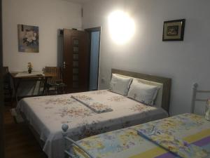 a bedroom with two beds and a table and a table at Cazare la mare vila Constanta in Constanţa