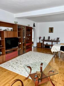 sala de estar con TV y mesa en Apartament Confort - Baile Olanesti, en Băile Olăneşti
