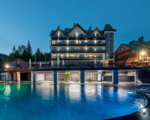 un hôtel avec une piscine en face d'un bâtiment dans l'établissement Hotel Podgorie Spa, à Bukovel