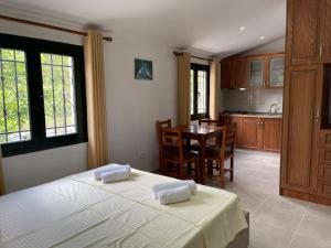 Cet appartement comprend une chambre avec un lit et une cuisine avec une table. dans l'établissement Hibroj Guesthouse, à Vlorë