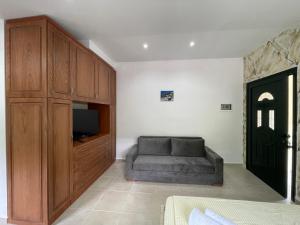 un soggiorno con divano e TV di Hibroj Guesthouse a Vlorë