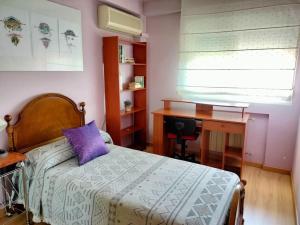 een slaapkamer met een bed, een bureau en een raam bij Apartamento Deluxe El Camino in Alcalá de Henares